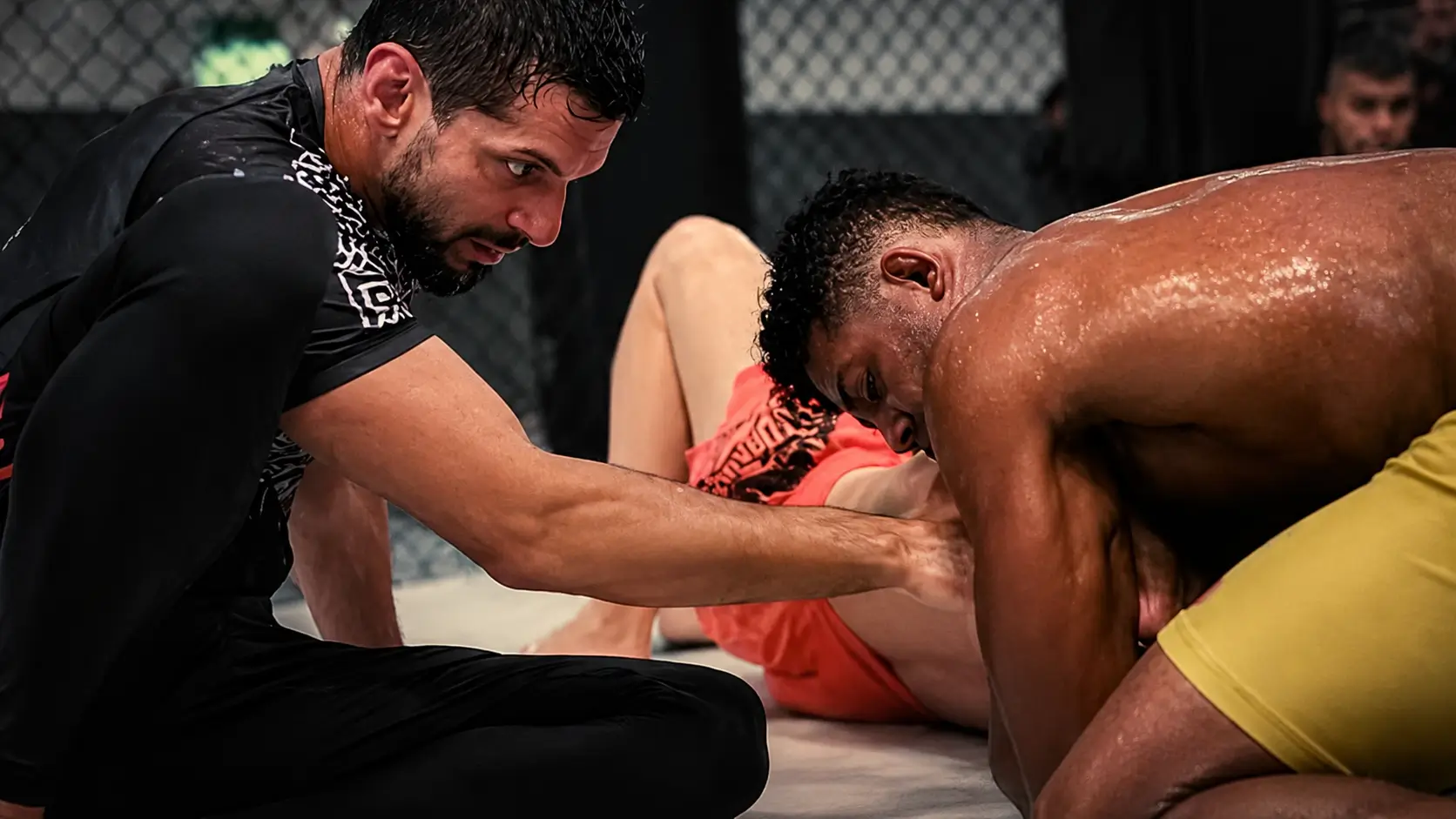 Erik Silva coaching two grapplers through a position on the mat